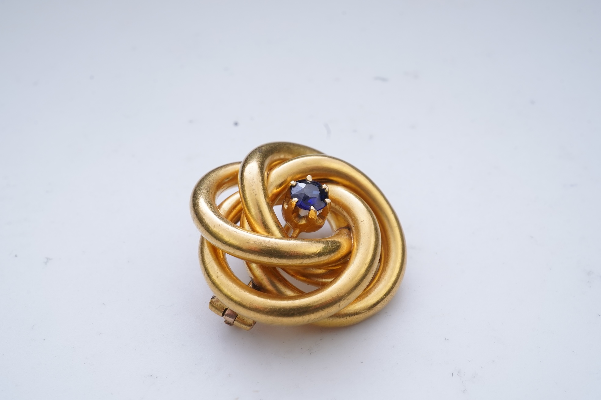 A gold and sapphire knot brooch, France, late 19th century